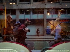 A run commuter with a backpack reflected in a shop window