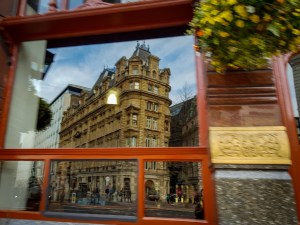 An old building reflected in the window of a London pub